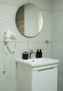 a white bathroom with a sink and a mirror at Iris Apartments in Ohrid +21 photos