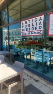 Un restaurante con mesas y un cartel en la ventana. en Antica Puglia, en Alberobello
