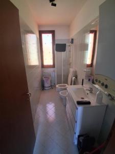 a bathroom with a sink and a toilet at Casa PC in Porto Corsini