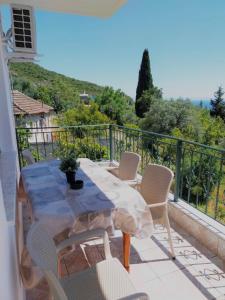 a table and chairs on a balcony with a view at Olga's apartment Drymades in Dhërmi