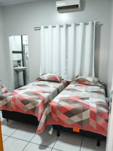 two beds sitting next to each other in a bedroom at Residencial Alves in Paragominas
