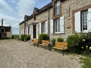 a group of benches sitting outside of a building at Le Clos du Hayer in Bercenay-le-Hayer
