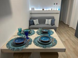 a table with plates and dishes on it in a living room at Florida Sunshine in Ardea