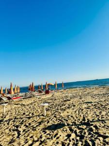 una spiaggia con sedie e ombrelloni e l'oceano di Guest House 1 a Durrës Altre 3 foto
