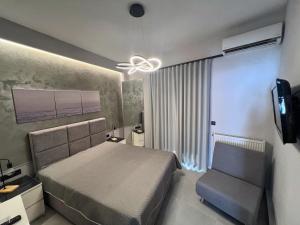 a bedroom with a bed and a ceiling fan and a chair at Selena Boutique in Neos Marmaras