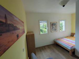 Villa Green Oasis في بوريتش: غرفة نوم بها سرير ونافذتين