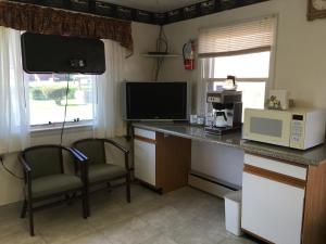 a kitchen with a counter with two chairs and a microwave at Red Carpet Inn - Gettysburg in Gettysburg