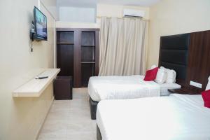 ヌアクショットにあるTwins Hotelのベッド2台と薄型テレビ付きのホテルの部屋