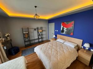 a bedroom with a bed and a blue wall at Trabzon Villa in Trabzon