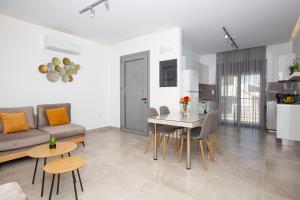 a living room with a couch and a table and chairs at RENI APARTMENT Faliraki in Faliraki +22 photos