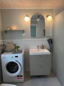 a bathroom with a washing machine and a sink at Hus Björklund in Hällefors +12 photos