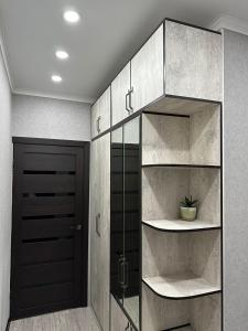 a walk in closet with a black door at Квартира in Shymkent