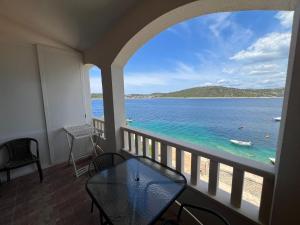 a balcony with a table and a view of the ocean at Apartman 6 Majba in Zaglavice