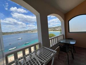 a room with a balcony with a view of the water at Apartman 6 Majba in Zaglavice