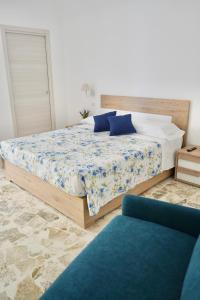 a bedroom with a bed and a blue couch at B&B Santa Filomena in Laterza
