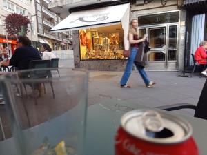 une femme marchant dans la rue devant un magasin dans l'établissement Habitación de lujo, à Saint-Jacques-de-Compostelle