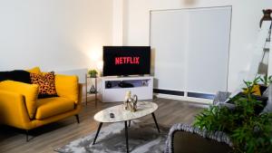 a living room with a yellow couch and a tv at Manchester City Centre Apt, with Free Secured Parking & Balcony, Sleeps 4-12less BLACK FRIDAY SALE ACROSS THE WHOLE OF NOVEMBER in Manchester