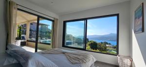 una camera da letto con una grande finestra con vista sull'acqua di Villa Haut Standing Stella Di Mare vue panoramique a Propriano