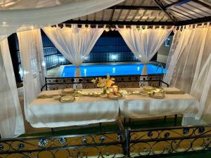 a table in a room with a bed with curtains at Summer house LejHana in Bihać