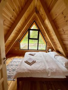 a bed in a room with a large window at A-frame Durmitor in Žabljak