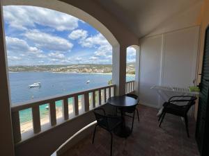 a balcony with a view of the ocean and a table and chairs at Apartman 5 Majba in Zaglavice