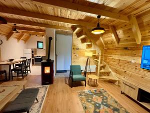 a living room with wooden walls and a spiral staircase at A-frame Durmitor in Žabljak