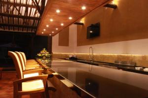 a kitchen with a counter with chairs and a sink at Misia Custodia Hotel Boutique in Barichara