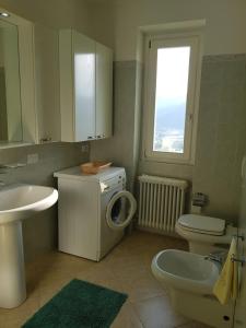 a bathroom with a toilet sink and a washing machine at Il Palazzo apartment with a view of the lake and nature in Calolziocorte