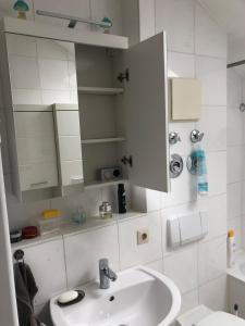 a white bathroom with a sink and a mirror at Bright attic apartment near Augsburg in Gersthofen +18 photos
