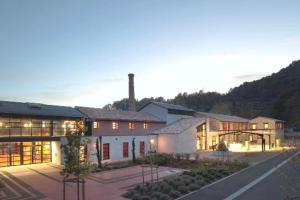 a large white building with a mountain in the background at L' amandier in Salernes