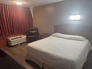 una habitación de hotel con una cama y una silla en Farrington Inn - North Brunswick, en North Brunswick