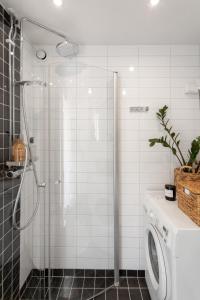 a bathroom with a shower and a washing machine at Stylish Studio Apartment - Center in Stockholm
