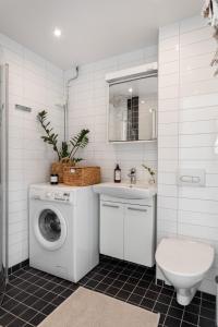 a bathroom with a washing machine and a sink at Stylish Studio Apartment - Center in Stockholm