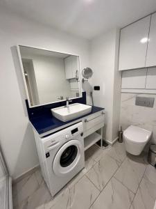 Un baño con lavadora y lavabo. en Feel Batumi Apart Hotel, en Batumi 7 fotos más