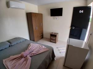 a bedroom with a bed and a flat screen tv at Pousada e Restaurante Kero Kero in Conceição do Araguaia