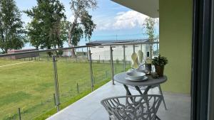 una mesa y una silla en un balcón con vistas a un campo en Dingi 105, en Siófok