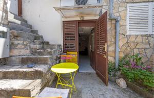 a yellow table and chairs in front of a building at Nice Home In Tisno With Wifi in Tisno