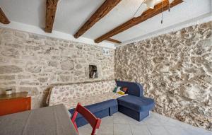 a living room with a blue couch and a stone wall at Nice Home In Tisno With Wifi in Tisno +16 photos