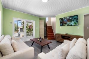 パーム・イーグル・ビーチにあるCasa Sol Stylish 4 BR Villa with Private Poolの緑の壁のリビングルーム(白い家具付)