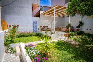 a backyard with a garden with flowers and a pergola at Skiathos Pearl in Skiathos