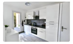 OrnexApt with garden in Ferney Ideal UN or CERN的带白色橱柜和水槽的白色厨房