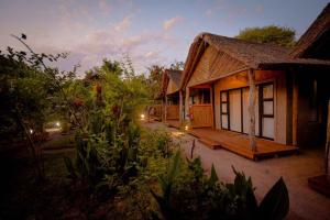 a small house with a deck next to a building at African Excursions Guest lodge in Khwai