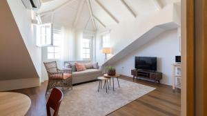 a living room with a couch and a tv at Carmo Apartamentos in Porto