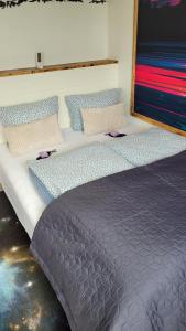a bed with three pillows on top of it at Apartment Fjordblick in Leikanger