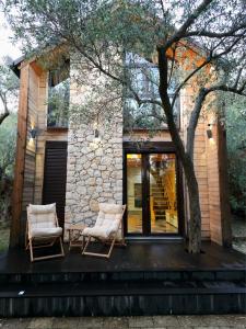 two chairs on the deck of a house at OLEA COTTAGE in Ulcinj