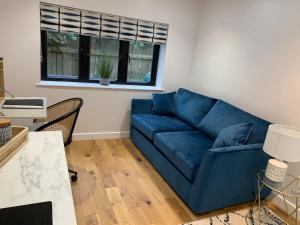 a blue couch in a living room with a window at Harvey Hideaway in Claypole