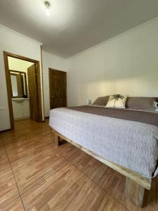 a bedroom with a large bed with a wooden floor at Pumakari Rapa Nui in Hanga Roa