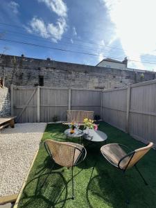 マーゲイトにあるStylish Seaside Home with Garden 2 minutes to Beachのパティオ(椅子2脚、芝生の上にテーブル付)