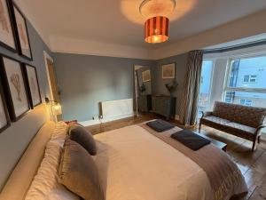 a bedroom with a large bed with a large window at Stylish Seaside Home with Garden 2 minutes to Beach in Margate