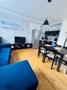 a living room with a blue couch and a table at Apartamenty Baltic Sea Żeglarska 10 nr1 in Grzybowo